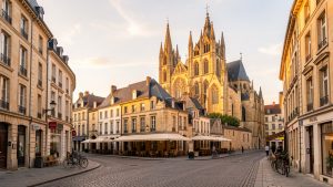 Vue éditoriale de Metz au lever du soleil, avec la cathédrale Saint-Étienne en pierre dorée de Jaumont dominant les rues du centre historique dans une atmosphère urbaine paisible de week-end.